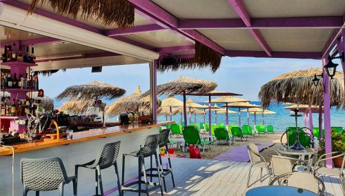 a bar on the beach with chairs and umbrellas at House Blerina - Sarti Chalkidiki in Sarti