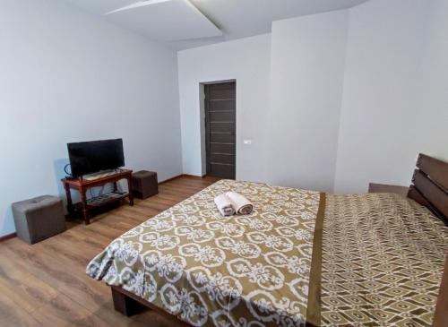 a bedroom with a large bed and a television at Sweet Home in Yerevan