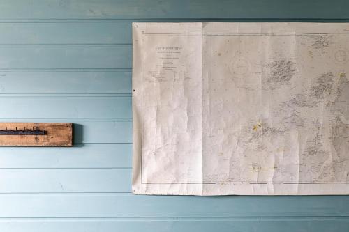 a map hanging on a blue wall with a clipboard at Eliassen Rorbuer in Reine