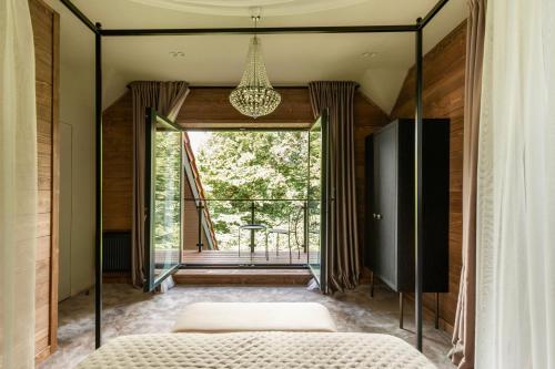 ein Schlafzimmer mit einem Bett und einem großen Fenster in der Unterkunft Poderey Villas in Jaremtsche