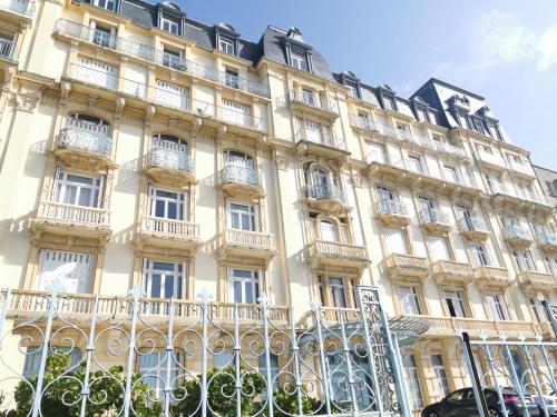 un gran edificio con una valla delante en Dieppe, Studio cosy front de mer en Dieppe