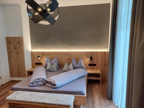 1 dormitorio con cama y lámpara de araña en Appartements König, en Merano
