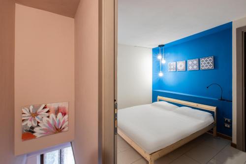 mały pokój z łóżkiem z niebieską ścianą w obiekcie Donna Elena - Apartment w Asti