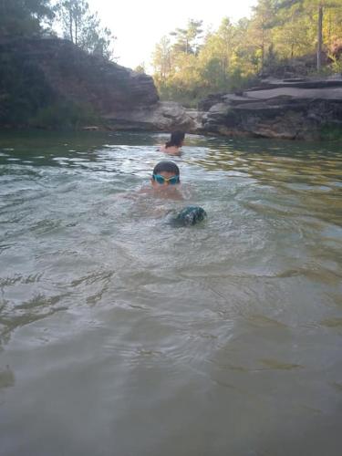 a man swimming in a river with a dog at El Desván del Campanero apartamento con jardín in Murillo de Gállego