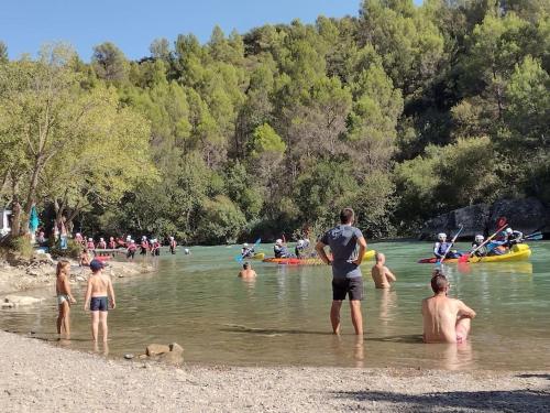 a group of people in the water at a beach at El Desván del Campanero apartamento con jardín in Murillo de Gállego