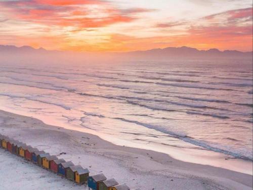 a group of containers on the beach at sunset at Cape Capsules in Muizenberg