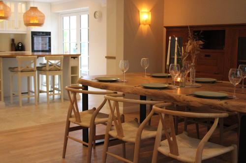 cocina y sala de estar con mesa de madera y sillas en Ferienhaus Mayland, en Humptrup