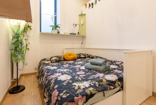 ein Schlafzimmer mit einem Bett mit einer blumengeschmückten Decke in der Unterkunft La Chambre Suspendue by Maison Brasseurs d'Etoiles in Lüttich