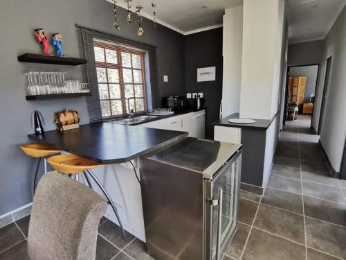 a kitchen with a black counter and a table and chairs at Living The Breede - Weaver Cottage in Malgas