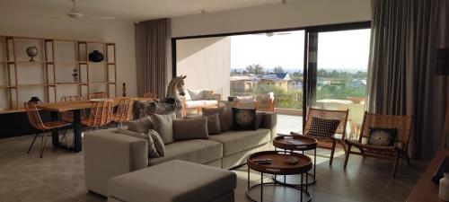 sala de estar con sofá y mesa en Superbe appartement avec vue mer et montagnes. en Tamarin