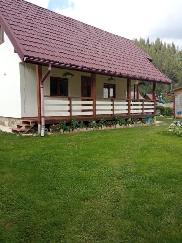 ein Haus mit einem Zaun und einem grünen Garten in der Unterkunft На Березові in Krivorovnya