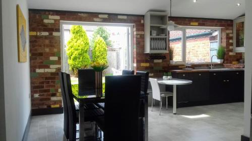 uma cozinha com mesa e cadeiras e uma sala de jantar em Stunning & Spacious Family Home. Midlands location em Coventry