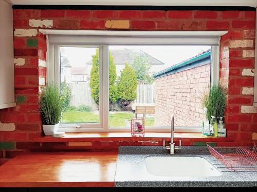 cocina con fregadero y ventana en Stunning & Spacious Family Home. Midlands location, en Coventry