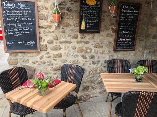 a restaurant with two tables and a stone wall at Duchesse Anne in Dinan