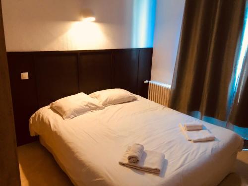 een slaapkamer met een bed met handdoeken erop bij Duchesse Anne in Dinan