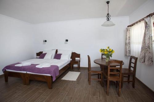 um quarto com uma cama, uma mesa e cadeiras em Kovács tanya - falusi szálláshely 
