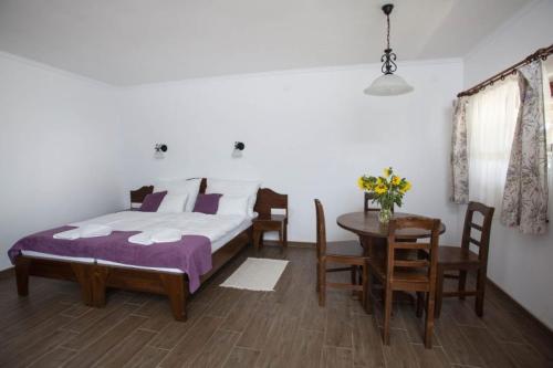 a bedroom with a bed and a table and chairs at Kovács tanya - falusi szálláshely in Kunmadaras