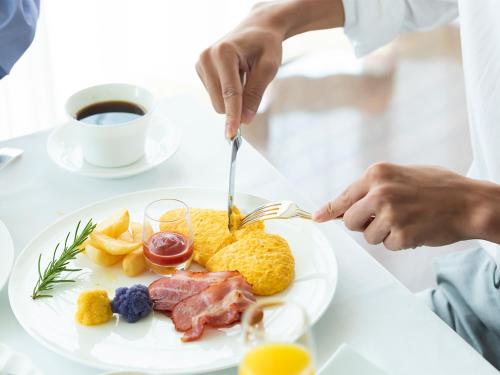 a person eating a plate of breakfast food at Hotel Francs in Chiba
