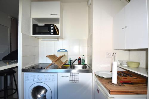 Il comprend une cuisine équipée d'un évier et d'un lave-linge. dans l'établissement Studio Gare St Roch 1er étage - Air Rental, à Montpellier