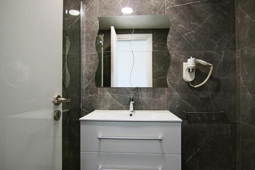 a bathroom with a white sink and a mirror at Phaedrus Living: Luxury Suite Nicosia 505 in Nicosia