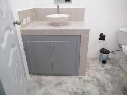 a white bathroom with a sink and a toilet at Casa merengue in Las Terrenas