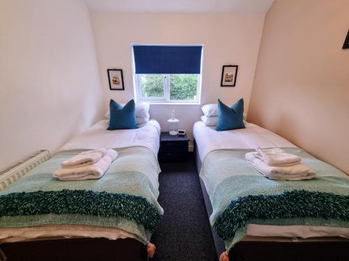 two twin beds in a room with towels on them at No.1 Bloom Apartments, Bath in Bath
