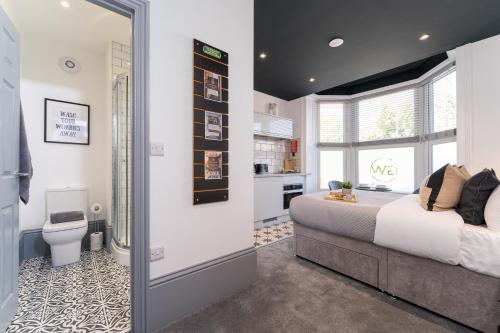 a bedroom with a bed and a bathroom with a toilet at The Madison - Premium Self Check-In Studios & Apartments in Southampton