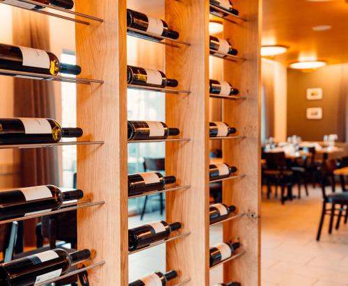 a wall of wine racks in a restaurant at Hotel Rössli Luterbach in Luterbach