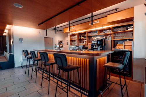 a bar with a row of stools at Hotel Rössli Luterbach in Luterbach