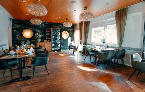 a dining room with tables and chairs and chandeliers at Hotel Rössli Luterbach in Luterbach