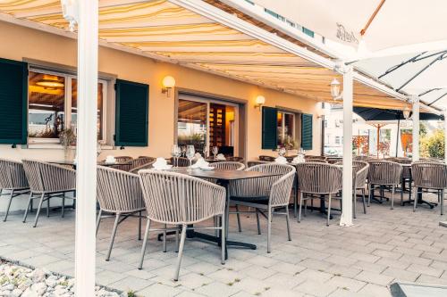 a patio with tables and chairs in a restaurant at Hotel Rössli Luterbach in Luterbach