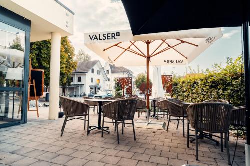 a patio with a table and chairs and an umbrella at Hotel Rössli Luterbach in Luterbach