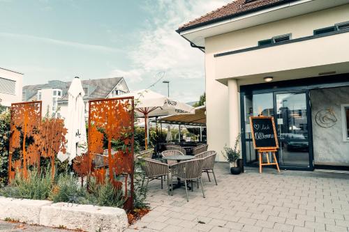 a patio with a table and chairs outside of a store at Hotel Rössli Luterbach in Luterbach