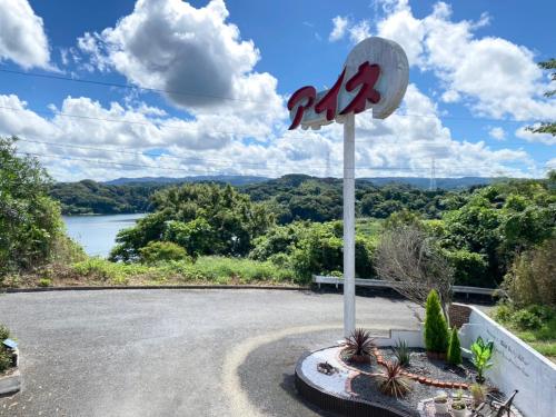 a sign on a road with a view of a lake at ホテル艶グループ　富津店 in Futtsu