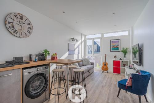 Il comprend une cuisine et un salon avec une table et un lave-linge. dans l'établissement R'Apparts T2 Le Belledonne View, à Grenoble