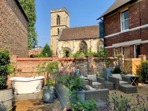 a garden in front of an old church at City Centre Luxury Holiday House with Outdoor Bath and Parking in York