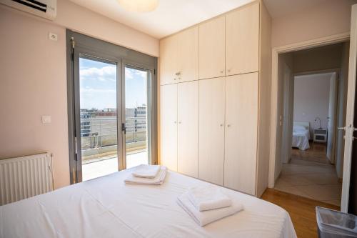 een slaapkamer met een wit bed en handdoeken bij Koukaki apartment 3 bedrooms 6 pers. in Athene