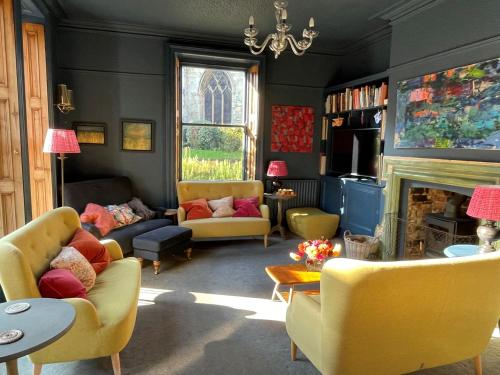 sala de estar con sillas amarillas y chimenea en City Centre Luxury Holiday House with Outdoor Bath and Parking, en York
