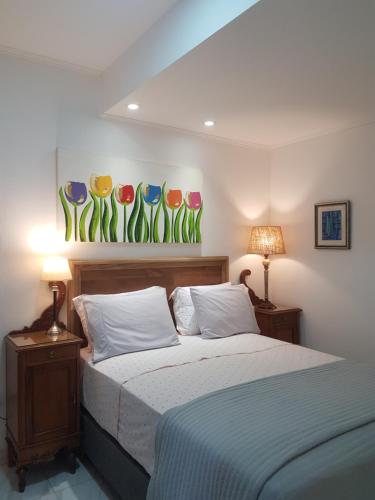 a bedroom with a bed with two lamps and a painting on the wall at Coqueto departamento in Puerto Iguazú