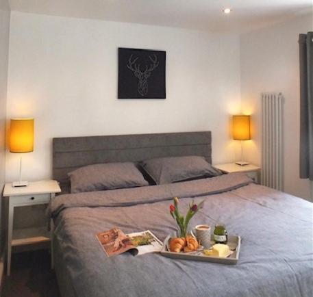 a tray of food on a bed in a bedroom at Boggle Dyke Cottage in Thornhill