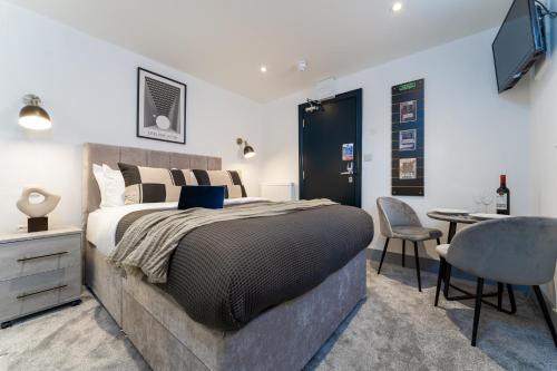 a bedroom with a bed and a desk and a chair at The Madison - Premium Self Check-In Studios & Apartments in Southampton