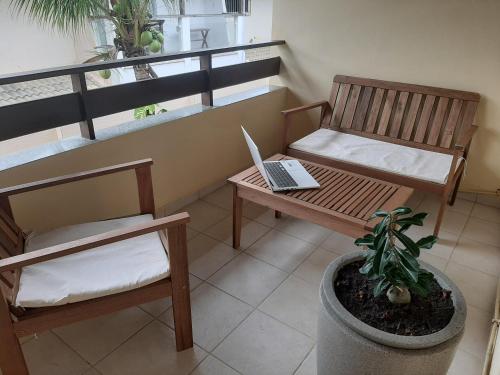 a balcony with a bench and a laptop on a table at Village Praia do Flamengo frente mar in Salvador