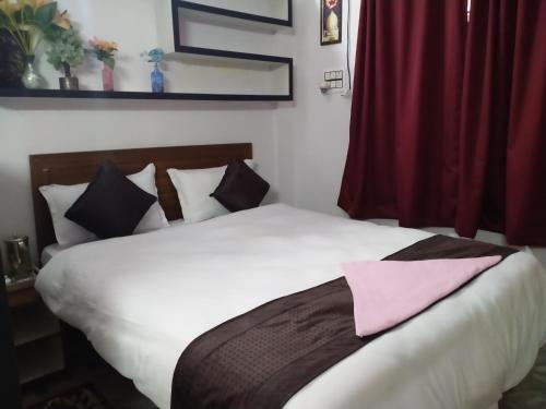 ein Schlafzimmer mit einem Bett und einem rosa Handtuch darauf in der Unterkunft Corporate Guest House in Ranchi