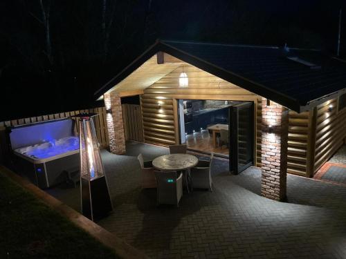 a small house with a table and a bed at Harewell wood lodge in Dacre