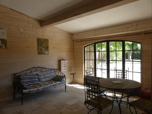 um quarto com uma cama, uma mesa e uma janela em chic et champêtre em Solliès-Pont