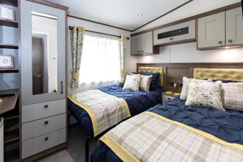 a bedroom with two beds and a tv at Silver Birches in Wisbech