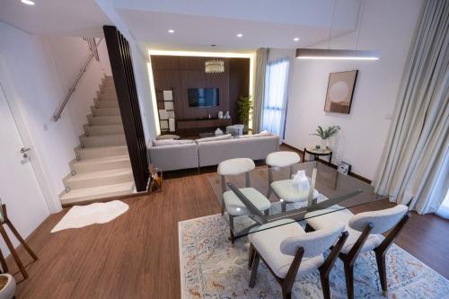 sala de estar con mesa, sillas y sofá en Villa Number 4 en Sharjah