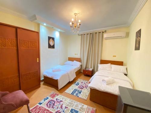 um quarto de hotel com duas camas e um lustre em Asma Pyramids View no Cairo