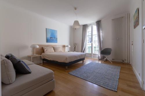 a living room with a bed and a couch at Bel appartement bourgeois au centre-ville de Biarritz in Biarritz