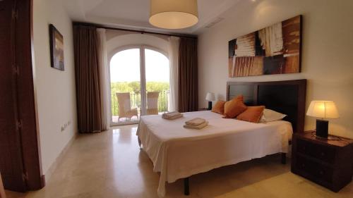 a bedroom with a large bed and a large window at Villa Fairways Golf By Mila Prieto in Arcos de la Frontera